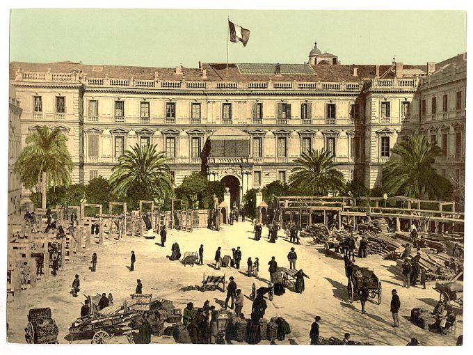 People, carts, and goods in the courtyard of an unidentified public building, possibly in France