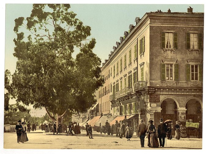 Street scene with people, tree, commercial buildings, possibly in France