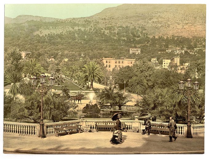 Resort area with palm trees, fountain, hotel, and promenade