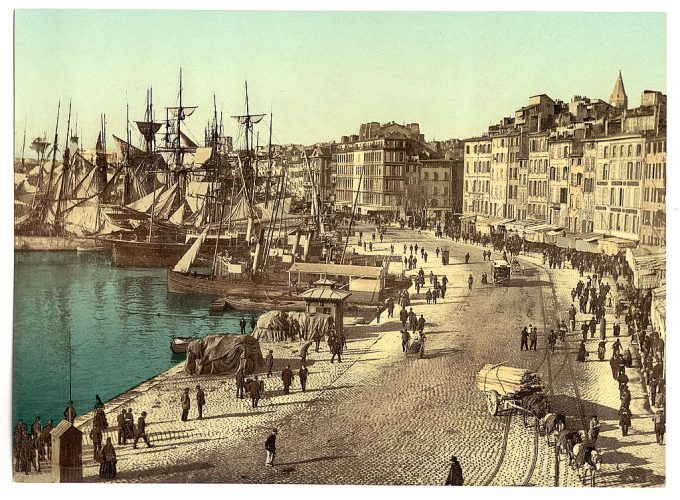Waterfront scene with ships at harbor and pedestrians